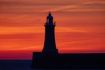 Drone closeup of the silhouette on the Tynemouth Lighthouse at sunrise in UK