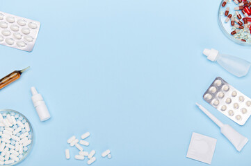 Flat lay. Medical pills, translucent capsules, blisters with dragees, drops and ampoules laid out...