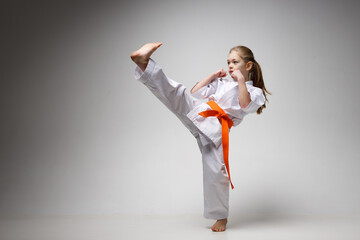 A strong kick, a girl in a kimono on a white background.