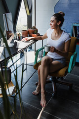 Young latin woman Working from Home on Desktop Computer i Loft Apartment. Creative Designer at home office in Mexico hispanic people