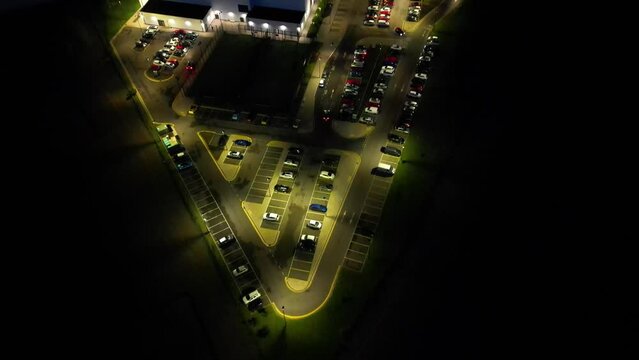 Night time drone football dover building with cars and parking during the evening.