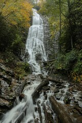 Vertical shot of a beautiful waterfall surrounded by rocks in a forest