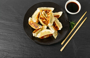 Gyoza Chinese Dumplings on Black Plate, Fried Vegetable Jiaozi, Chicken Momo Pile, Asian Gyoza Group