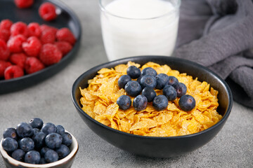 Tasty cereal with blueberries and raspberries on a marble table