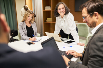 Ältere Geschäftsfrau als Referentin in einem Team Meeting