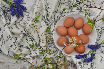 easter eggs and white, blue flowers. Flat lay. Wodden table and fabric.