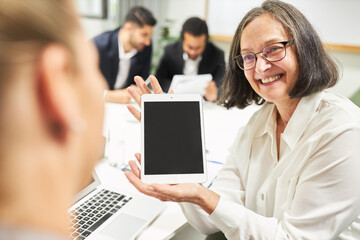 Business Frau zeigt Trainee eine Tablet Computer Innovation