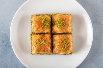 Pistachio Turkish baklava on a white plate.Close-up of four slices of baklava