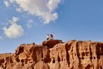 two woman tourists smiling on top of rock formations in wadi rum desert