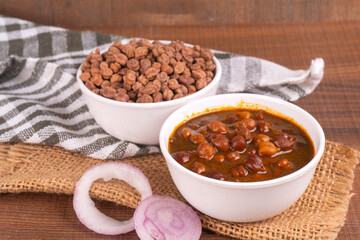Chole masala or chana indian vegan food made of cooked chickpeas, tomatoes and cumin decorated with onion rings.