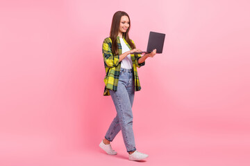 Full body size photo of walking young woman wear casual clothes hold working laptop writing email her hr manager isolated on pink color background