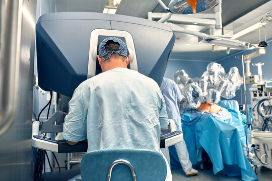 Carrying out an operation using a robot, a robot surgeon with manipulators, a modern operating room, surgeons people perform an operation using a surgeon's robot through the control panel.