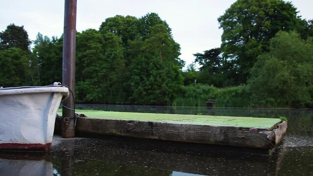 Pan across a still river dock left to right