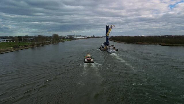 Aerial of a crane being transported on the inland canal of Zwijndrecht, The Netherlands. (AHOY)