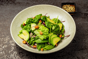 Green salad with red cabbage, avocado, spinach, lettuce and pistachio nuts