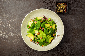 Green salad with red cabbage, avocado, spinach, lettuce and pistachio nuts