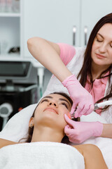 Obraz na płótnie Canvas Cosmetology service,cosmetic procedure,Acne therapy,cosmetologist performs facial treatments for a customer at an aesthetic medical clinic