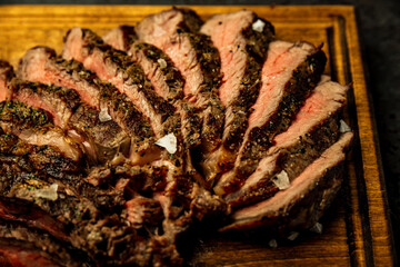 Close-up of sliced boneless ribeye steak served on a wooden board in a restaurant