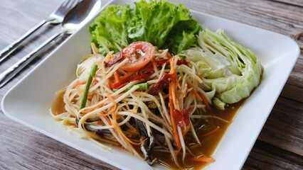 Top view table spicy green papaya salad or Som Tam, delicious Thai traditional popular street food.