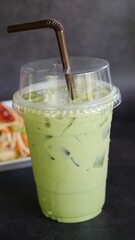 Iced Green Tea in take away cup isolated on black background.
