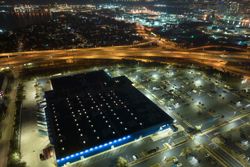 Aerial night view of many cars parked on parking lot with lines and markings for parking places and...