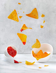 Flying corn nachos or chips and ketchup. Levitating creative food shot. Delicious snack concept....