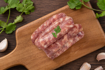 Raw Taiwanese sausage in garlic flavor in a plate on wooden table background.