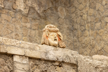 Fototapeta na wymiar House of Neptune and Amphitrite with marble mask on the wall, Herculaneum, Campania, Italy