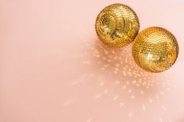 Gold shiny balls with sequins on a pink background. Web banner with copy space.