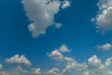 White puffy cumulus clouds on summer blue sky
