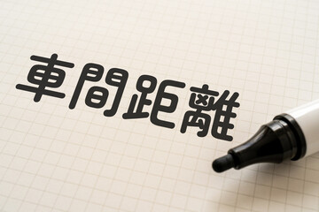 車間距離と書かれたノートとマーカー