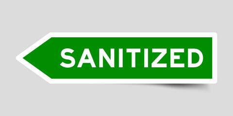 Green color arrow shape sticker label with word sanitized on gray background