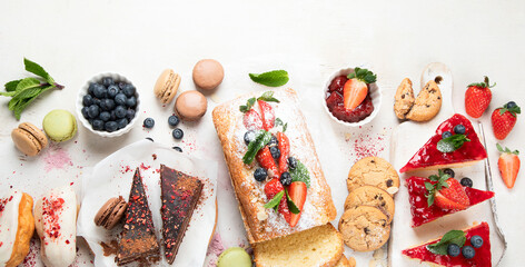 Table with various cookies, cakes and fruits. Delicious dessert table.