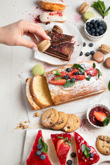 Table with various cookies, cakes and fruits. Delicious dessert table.