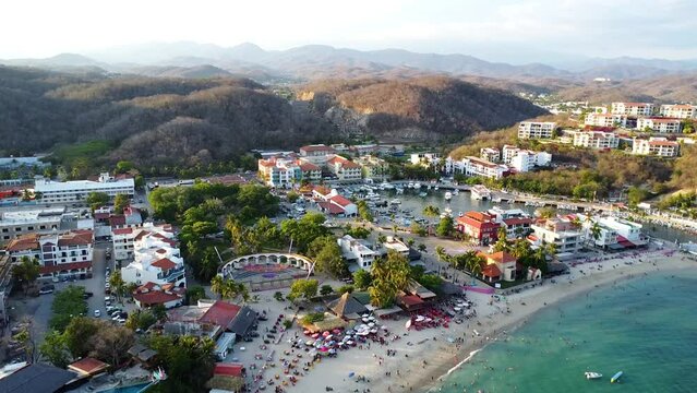 drone video 4k clip of hotels in huatulco mexico oaxaca summer destination in america beach sunny day and mountains in the background