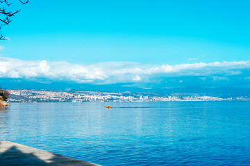 Obraz premium Beautiful blue sea with fishing boat. View of Rijeka city, Croatia