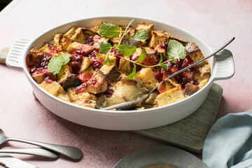 Homemade bread pudding with jam on a pink  concrete background. Selective focus, copy space