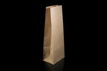Recyclable craft paper bag for purchases, gifts and takeaway food mock up on black background. Environmentally friendly than single-use plastic bags