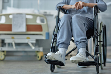 Close-up of senior patient with disability sitting in wheelchair during rehabilitation in hospital ward