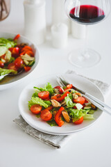 Fresh salad with mussels and tomatoes on white wooden table