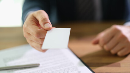Businessman banker giving credit bank card to client closeup. Business investment concept