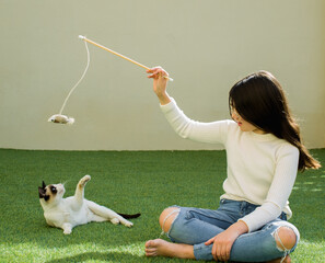 Girl plays with cat in her backyard.rescued and adopted cat enjoys her new foster family.
