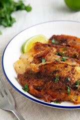 Homemade Pan Seared Tilapia on a Plate, side view. Close-up.