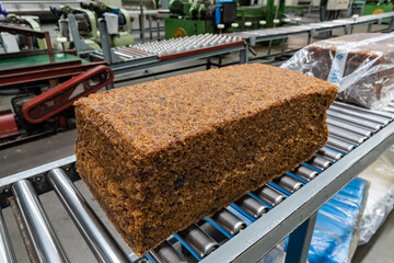 The natural rubber bales products on the industrial automatic conveyor belt machine in a rubber...