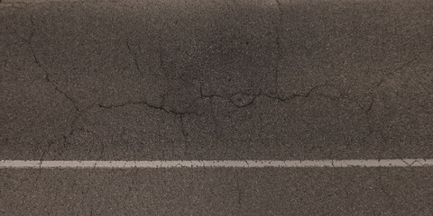 top view of surface of asphalt road made of small stones and sand with cracks