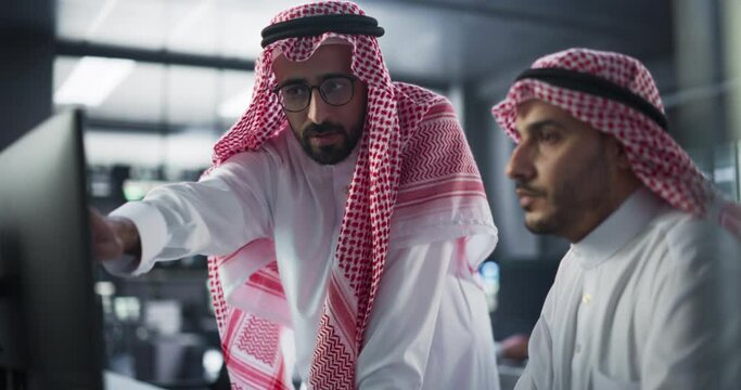 Young Arab Software Developer Working on Computer, Discussing Project with Team Leader. Middle Eastern Data Protection Center with Servers, Storage Hardware and Cyber Security Research