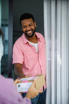 Happy man receiving parcel at doorway