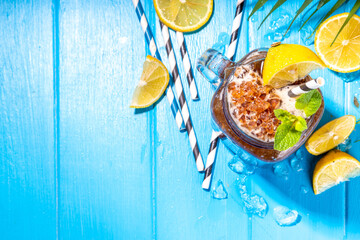 Southern Sweet Tea Slushy. Cold summer tea slush dessert, made with crushed iced tea and lemon juice, on sunny blue wooden background copy space