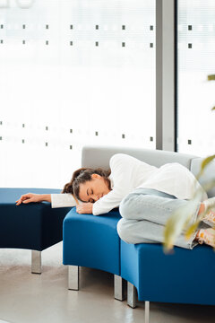 Tired Young Woman In Lab Coat Lying On Sofa