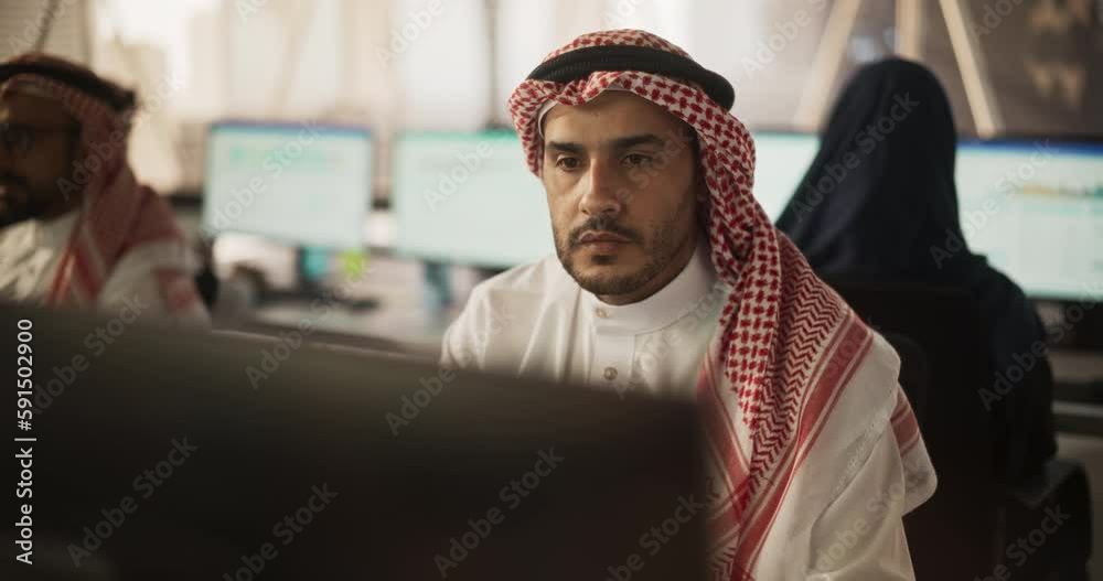 Poster Portrait of a Middle Eastern Engineer Working on Desktop Computer in a Fintech Startup Company. Arab Software Developer Researching New Ideas to Problem Solve a Technical Assignment. Warm Color Edit